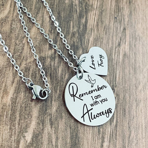 Silver Memorial Necklace engraved with a dove bird and the phrase "Remember I am with you Always". next to the round pendant is a heart charm engraved with "Love Troy" both charm pendants are attached with a cable chain with lobster clasp