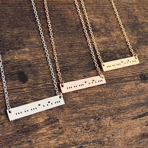 Morse code bar necklace that represents the word "sisters" in silver, rose gold, and yellow gold.