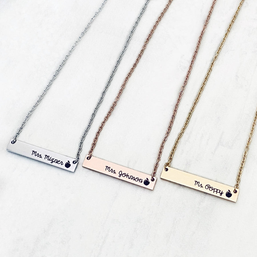 Silver, Rose Gold, and Yellow Gold stainless steel horizontal  bar necklace engraved with teacher's name and an apple charm. attached to a stainless steel cable chain