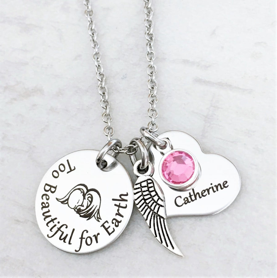 Silver Round pendant charm necklace engraved with infant angel baby and phrase "Too beautiful for earth" along with an angel wing charm, october pink birthstone and heart charm engraved with the name Catherine