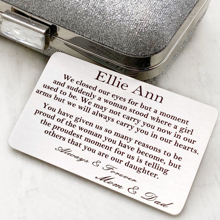 Silver Stainless Steel Wallet Insert card measuring 2 1/8-inches by 3 3/8-inches. Card is engraved with the saying “We closed our eyes but for a moment and suddenly a woman stood where a girl used to be. We may not carry you in our arms, but we will always carry you in our hearts. You have given us so many reasons to be proud of the woman you have become, but the proudest moment for us is telling others that you are our daughter. Always & Forever.” and signed Mom & Dad