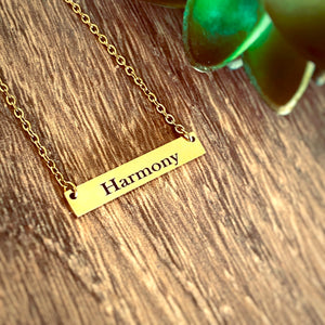 Word "Harmony" engraved on a Yellow Gold bar necklace. Word of the year