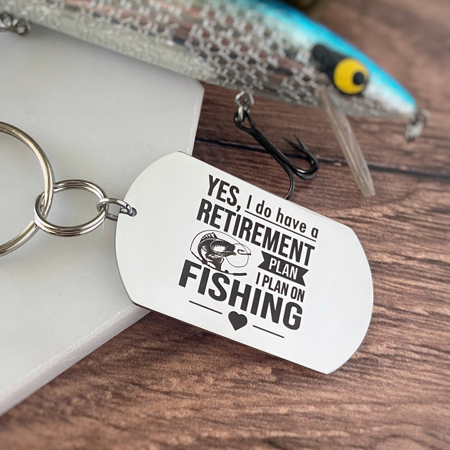 Silver stainless steel dog tag keychain engraved with the phrase, "Yes. I do have a retirement plan. I plan on fishing"
