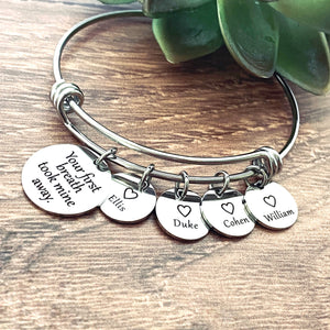silver stainless steel wire bangle charm bracelet with one 3/4" charm engraved with the saying "your first breath took mine away". next to the main charm are 4 1/2" round charms engraved with a heart and the names ellis duke cohen and william