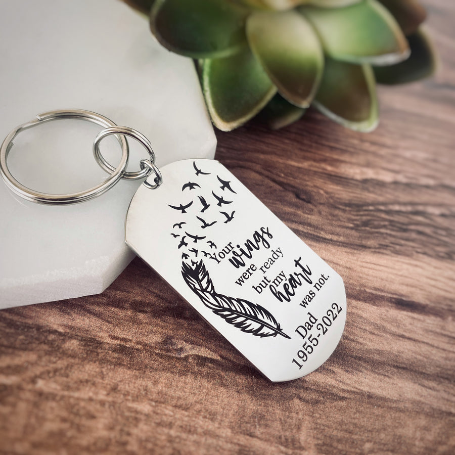 silver engraved memorial keychain with the phrase "Your wings were ready by mom heart was not." with the name "Dad" and the year of birth 1955 and the date of death 2022