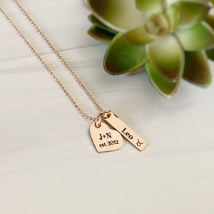 Rose Gold mom necklace with  heart charm engraved with parents initials "J + N" and wedding year "2012". rectangle name charm with the name "Leo" and a taurus zodiac sign.