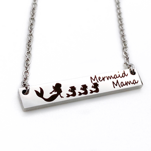 engraved 1.2-inch by .25 inch bar necklace in silver gold or rose gold and engraved with a mom mermaid image and your choice of mermaid babies. Engraved with the verbiage "mermaid mama"