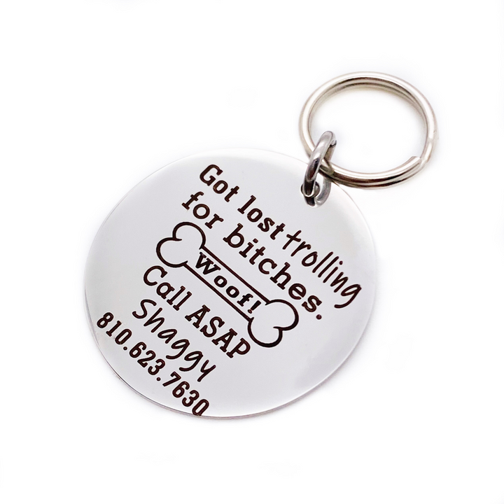 Silver stainless steel dog collar id tag with black engraving "Got lost trolling for bitches. Call ASAP" with a picture of a dog bone, pets name and telephone number